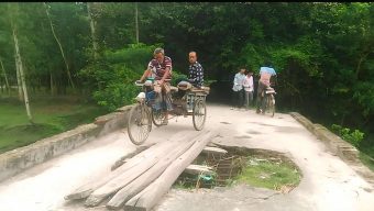 পুরোনো ব্রীজের ওপর কাঠ ফেলে ঝুঁকিপূর্ণভাবে চলাচল করছে সাধারণ মানুষ।