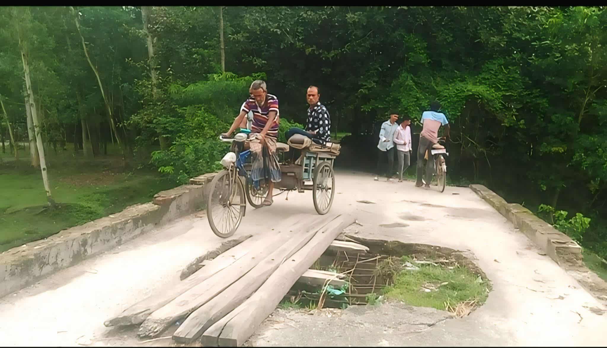 পুরোনো ব্রীজের ওপর কাঠ ফেলে ঝুঁকিপূর্ণভাবে চলাচল করছে সাধারণ মানুষ।